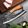 A hand-forged boning kitchen knife with a black and white blade and a wooden handle rests on a dark surface next to some meat
