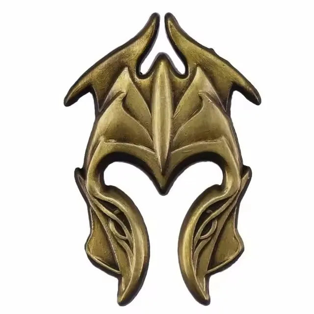 A vintage gold-toned enamel pin featuring a stylized leaf or tribal design.