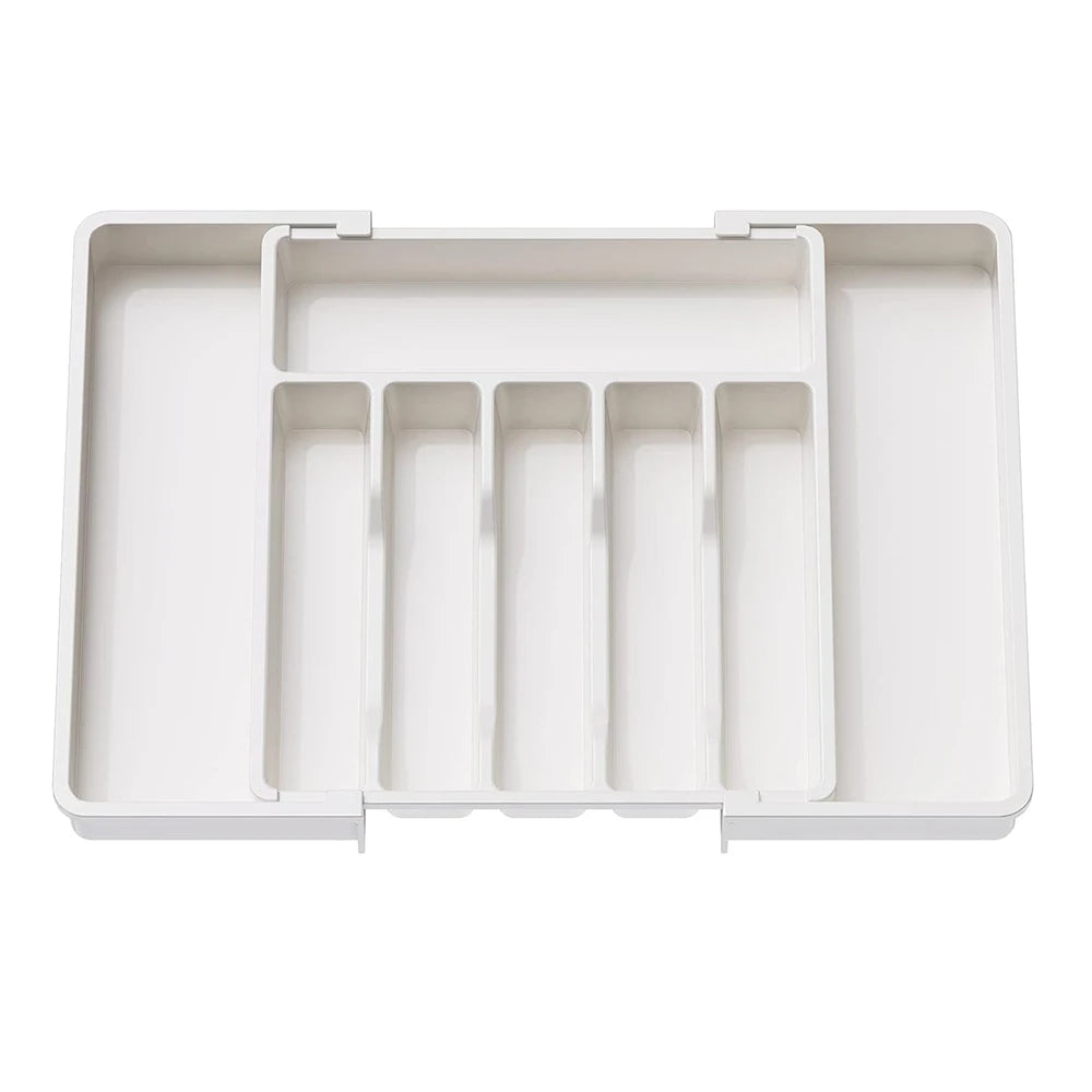 A white adjustable plastic flatware organizer tray with multiple compartments.
