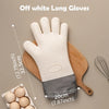 A pair of off-white long silicone baking gloves resting on a wooden cutting board next to eggs.