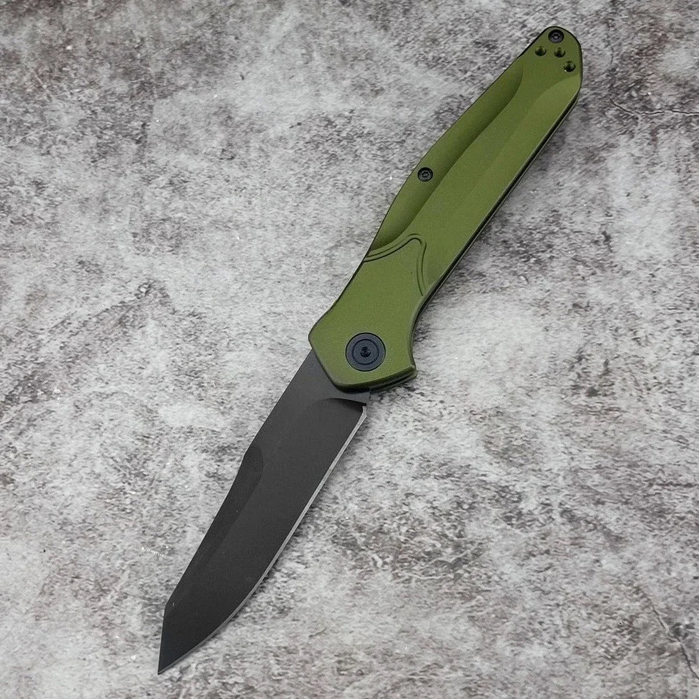 A folding pocket knife with a green handle and black blade resting on a gray surface.