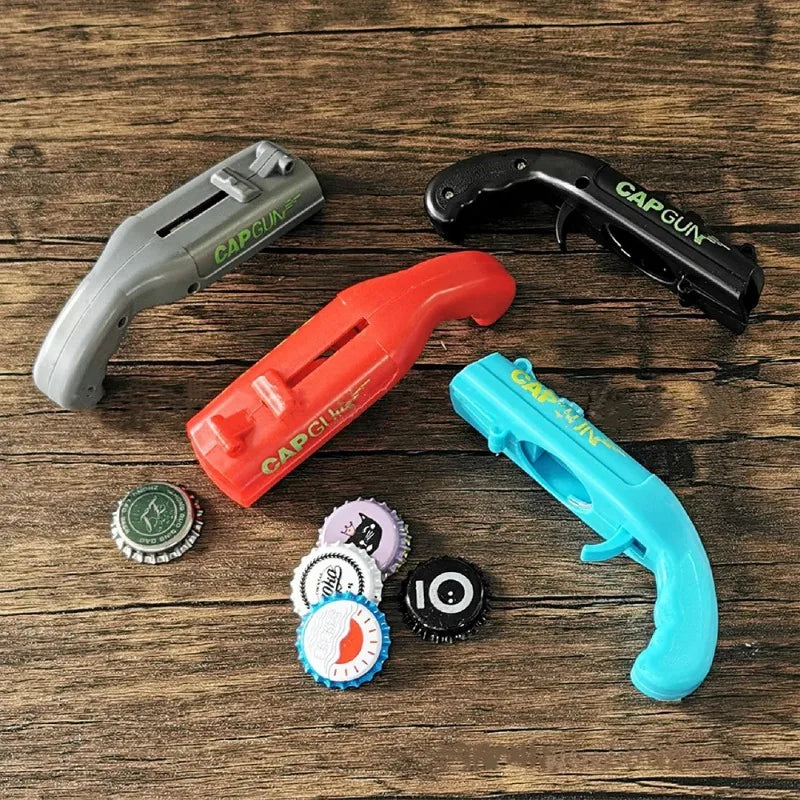 Three colored cap gun tools are displayed on a wooden surface, alongside several bottle openers.