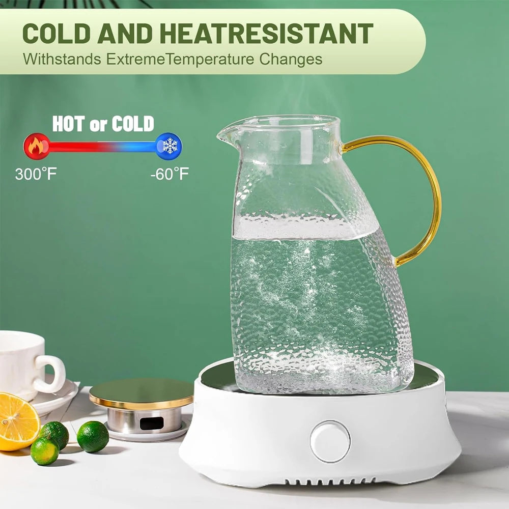 A clear glass water jug filled with ice, sitting on a white electric heating base.