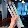 A hand holds a set of colorful alloy chopsticks with translucent pink and green accents.
