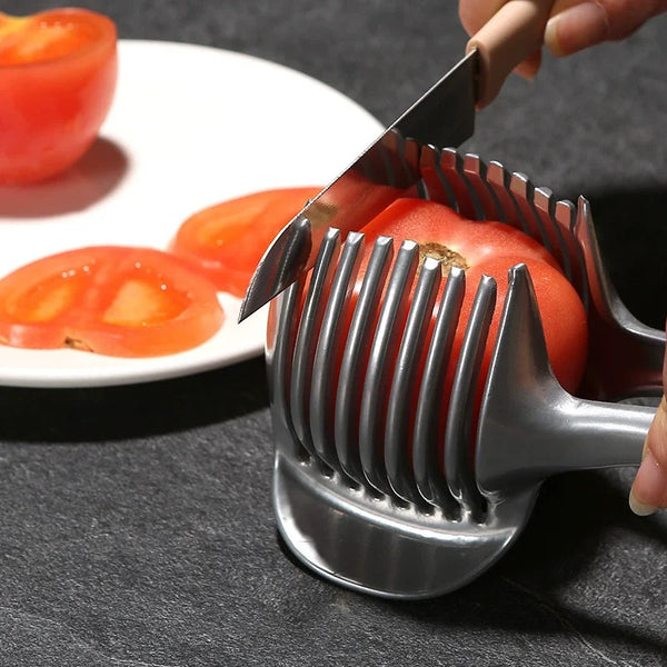 Eine Hand benutzt einen Edelstahl-Obstschäler, um eine Tomate auf einer dunklen Oberfläche zu schneiden.
