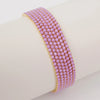 A close-up of a purple acrylic elastic bracelet stacked on a white wrist.
