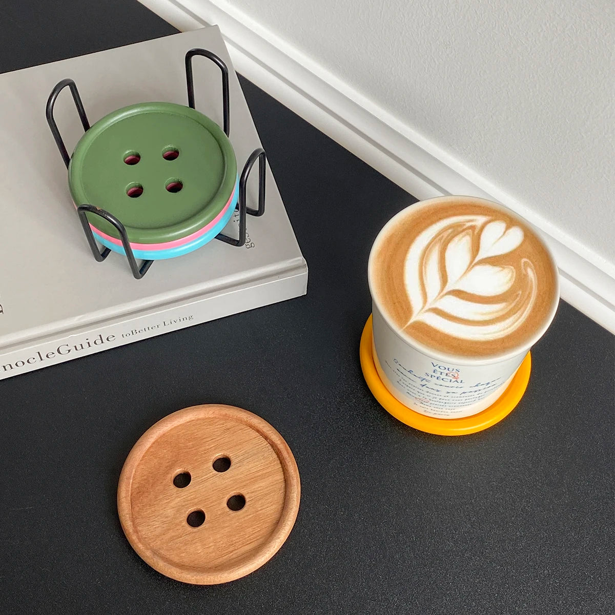 A set of six wooden coasters with an iron rack displayed on a light-colored book.