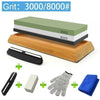 A set of multi-grits knife sharpening stones including a green and black stone, a wooden block, a knife, a white block, and a