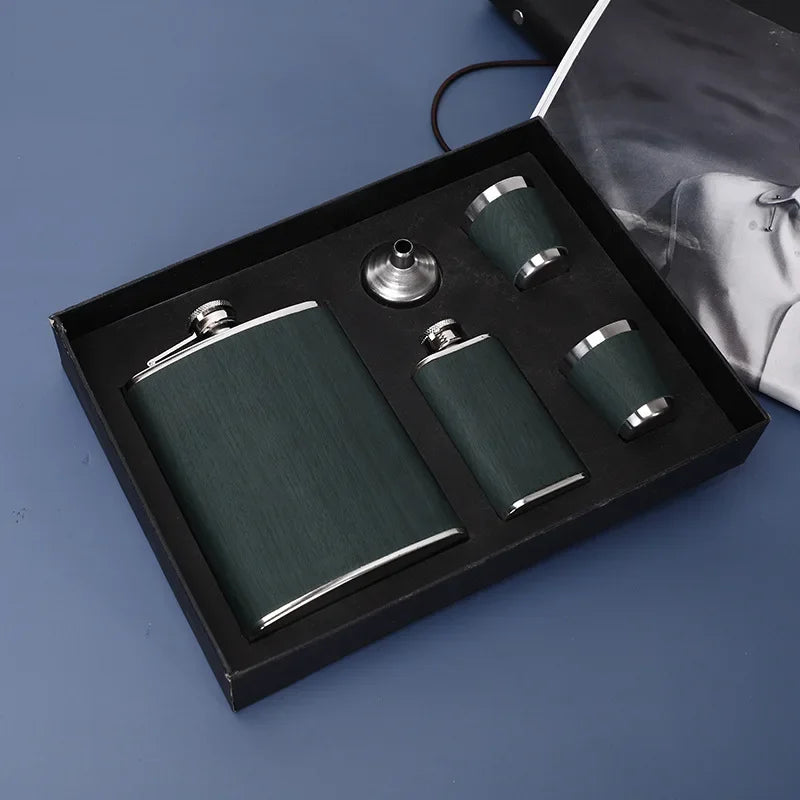 Una caja negra que contiene un juego de destiladores de acero inoxidable portátil con tres matraces cilíndricos y una tapa.