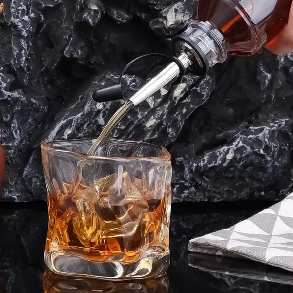 Edelstahl-Weinflaschenverschluss und -gießset, das bernsteinfarbene Flüssigkeit in ein Eisglas gießt.