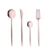 A set of four rose gold flatware pieces including a dinner fork, salad fork, soup spoon, and dessert spoon.