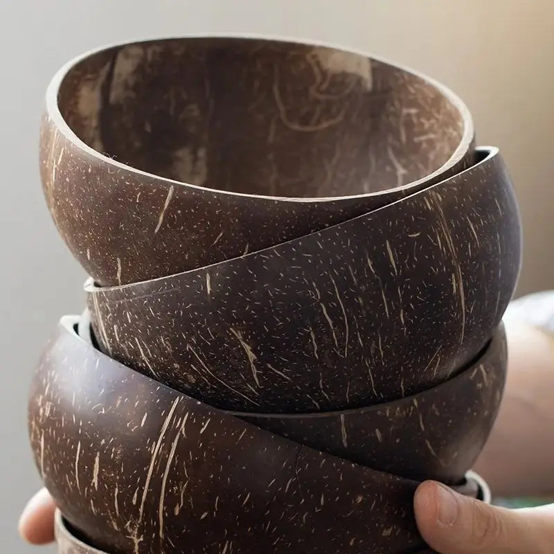 A stack of dark brown natural coconut shell serving bowls.