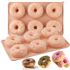 A pink silicone mini donut cake pan set with six round donuts and three glazed donuts.