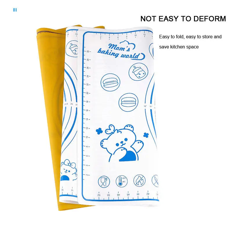 A white silicone rolling pin and baking mat set shown next to a yellow cloth, emphasizing its ease of folding.
