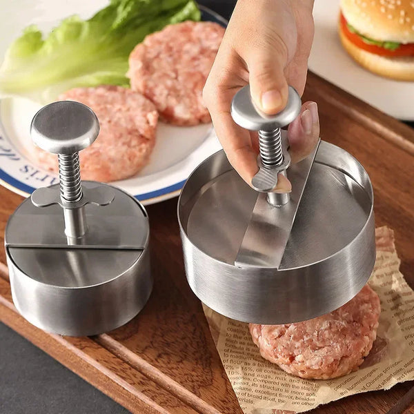 Eine Hand presst rohes gemahlenes Fleisch in eine runde Pfanne mit einer professionellen Edelstahl-Fleischpresse.
