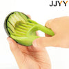 A hand is holding a bright green fruit slicer and corer tool, demonstrating its use.