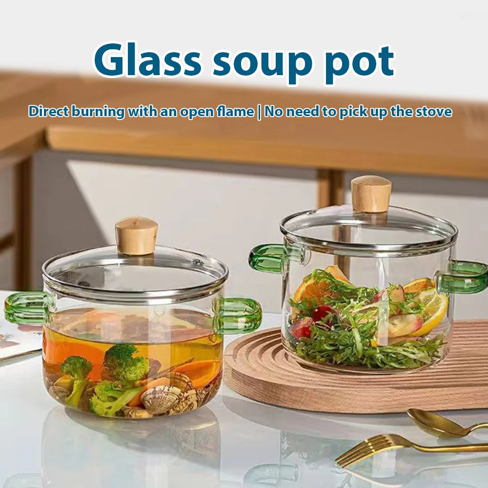 A glass soup pot with vegetables is being cooked directly on an open flame.