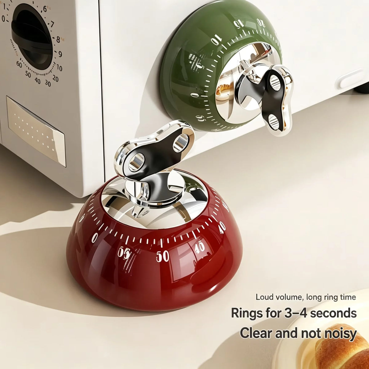 A red magnetic kitchen timer with a clear glass top and silver ring, next to a green digital timer.
