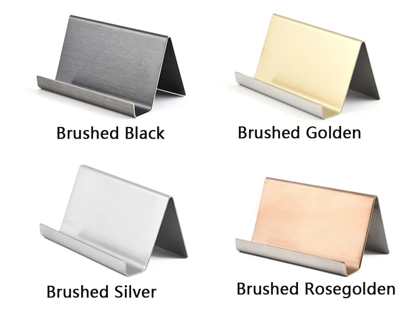 Cuatro soportes de tarjetas de acero inoxidable cepillado en acabados negro, dorado, plateado y rosa dorado.