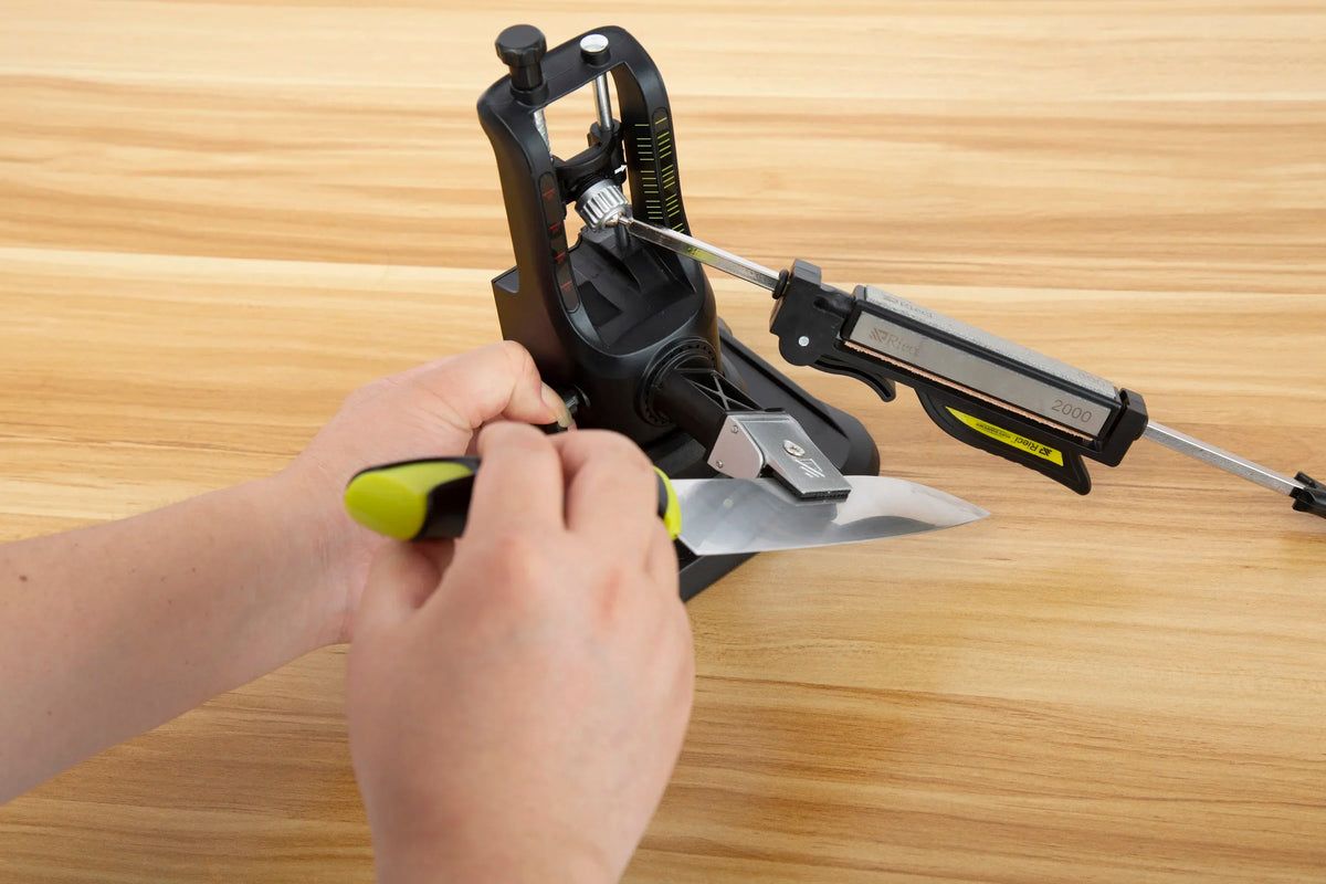 A hand is using a professional diamond knife sharpener set to sharpen a blade.