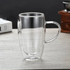 Klare doppelwandige Borosilikatglas-Kaffeetasse auf einer hellen Holzoberfläche.