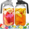 Botella de vidrio con asa llena de una bebida de color naranja y rodajas de cítricos.