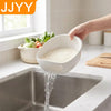 A hand is pouring white rice from a perforated bowl into a kitchen sink.