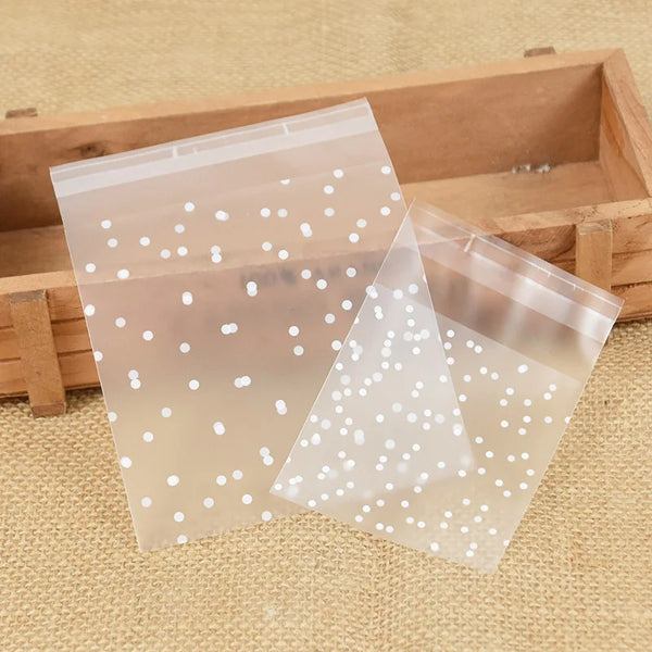 Klare Plastik-Süßwaren-Kekshüllen mit weißen Punkten werden in einer Holzkiste präsentiert.