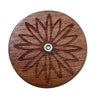 A round wooden bread scoring tool with a decorative star pattern and a central metal hole.