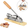 Stainless steel manual nut cracker tool with a wooden handle and cutting mechanism shown on a wooden board.