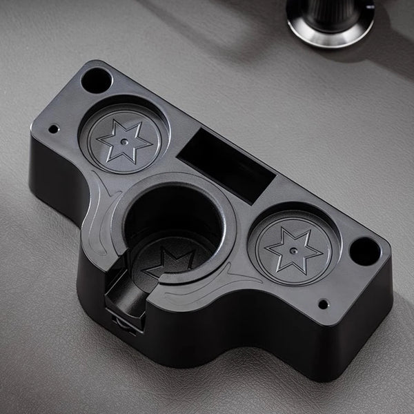 A black universal coffee tamper base with star-shaped indentations for espresso tools.