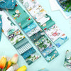 A collection of colorful patchwork cotton fabric strips in various floral and nature patterns laid out for sewing and craftin