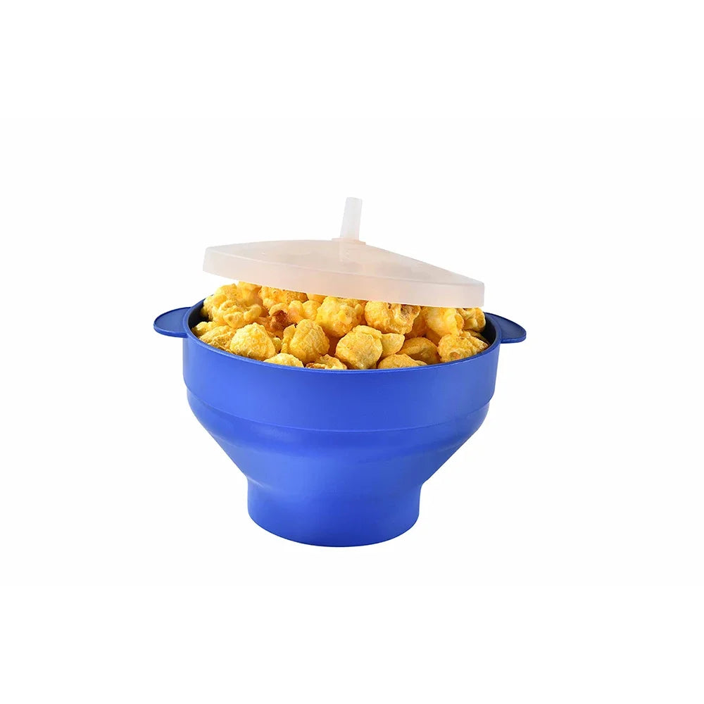 A blue silicone microwave popcorn bowl with a clear lid and a white spoon is shown.