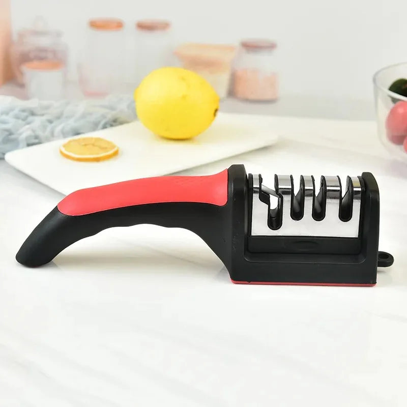 A black and red handheld knife sharpener is shown next to a lemon and some glass jars.