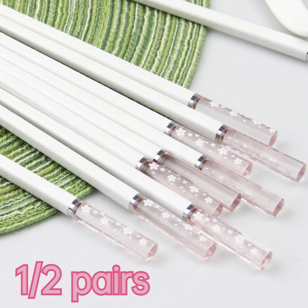 Ein Satz von 1/2 Paar durchsichtigen rosa Amber Kirschblüten-Stäbchen auf einem grün gestreiften Tuch.