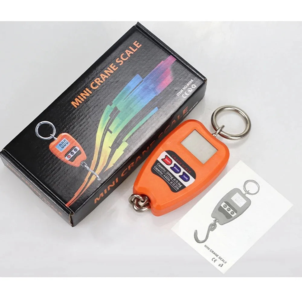 A mini crane scale in orange and black packaging with a key ring attached.
