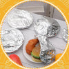 A plate of food items wrapped in aluminum foil, including a burger and a piece of bread.