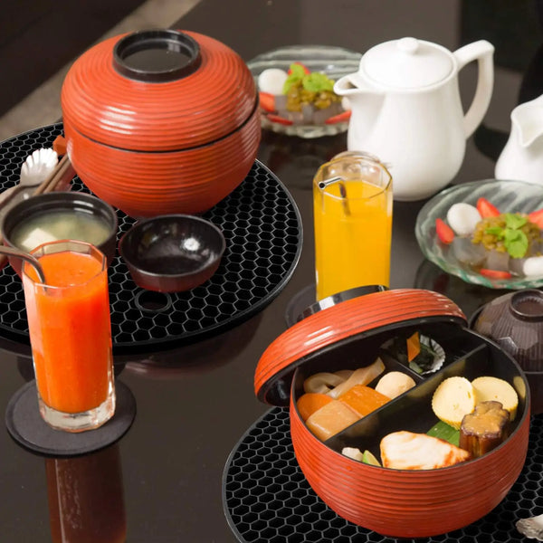 Serviertable mit Orangensaft, kleinen Schüsseln und einem terrakottafarbenen Gefäß mit Speisen