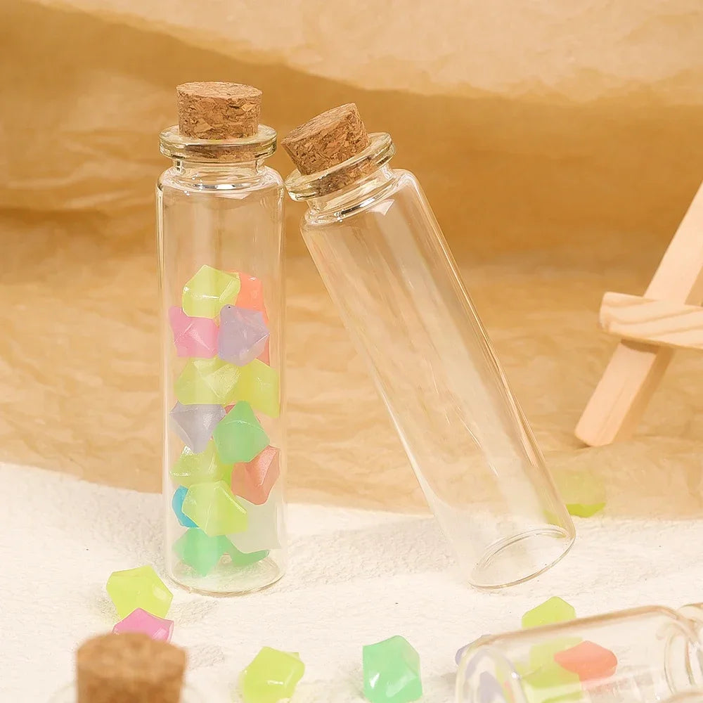A set of decorative glass bottles filled with colorful, translucent stones and topped with corks.