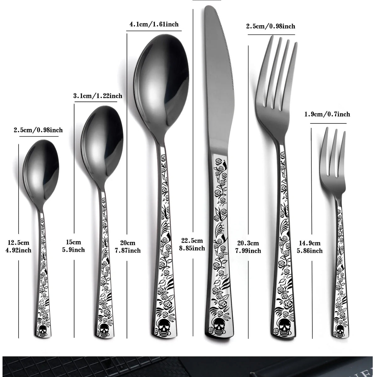 A set of stainless steel cutlery featuring a skull pattern on the handles, including a spoon, fork, and knife.