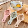 A multi-piece set of silicone egg white and yolk separators in pink, mint green, and beige, shown with a raw egg.