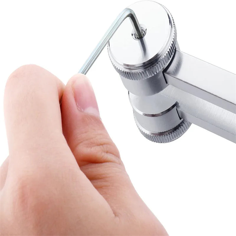 A hand is holding a silver tuning fork with a metal prongs, demonstrating the acoustic tuning device.