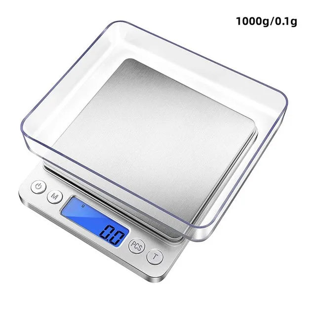 A clear plastic container with a stainless steel weighing platform and a digital display showing 0.0 grams on a precision kit