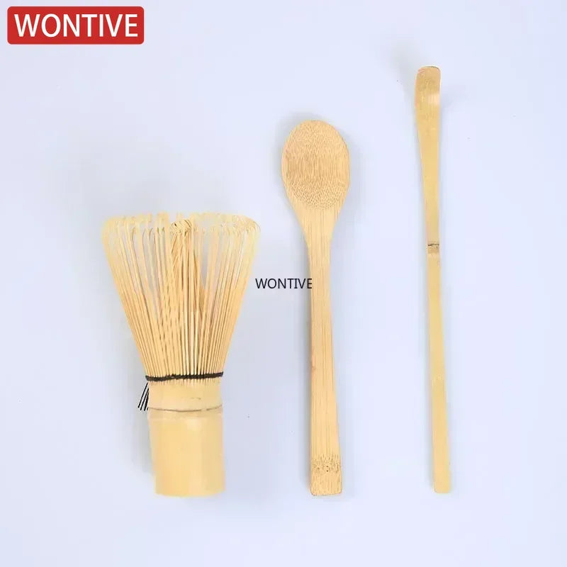 A set of traditional bamboo and ceramic matcha tea tools including a whisk and a scoop.