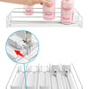 A clear adjustable spring can dispenser rack holding pink and white liquid bottles for kitchen or fridge storage.