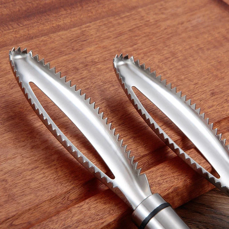 A pair of stainless steel fish scale scraper and tweezers set resting on a wooden surface.