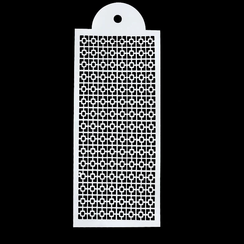 A white plastic cake stencil with an intricate geometric pattern on a black background.