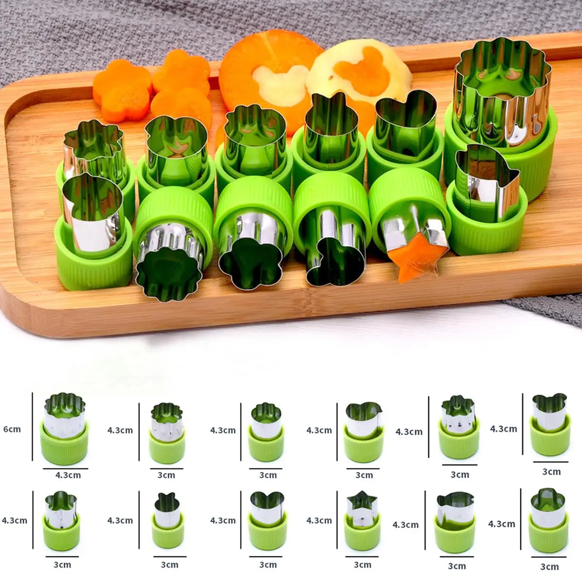 A set of 12 stainless steel vegetable and fruit molds in various shapes and colors displayed on a wooden tray.