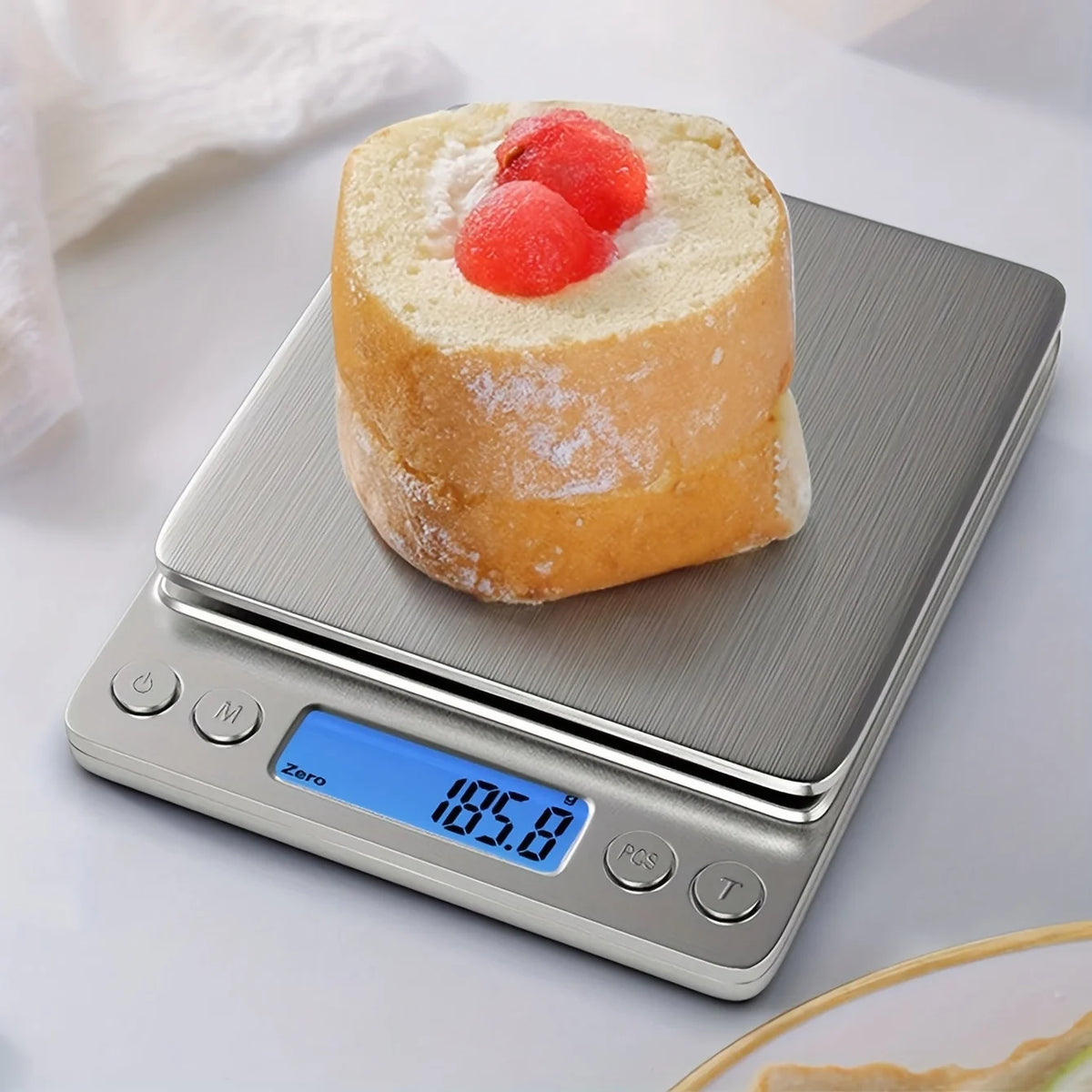 A round piece of bread topped with fruit is placed on a silver digital kitchen scale.