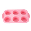 A pink nonstick silicone baking set with multiple round molds for cakes and desserts.
